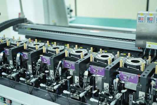Industrial production machine bed with multiple circular fixtures and purple modules